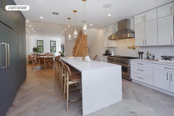 a large white kitchen with lots of counter space and painting on the wall