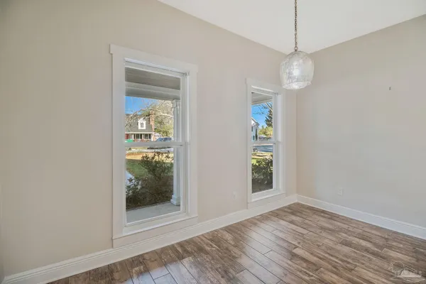 a view of empty room with wooden floor and window