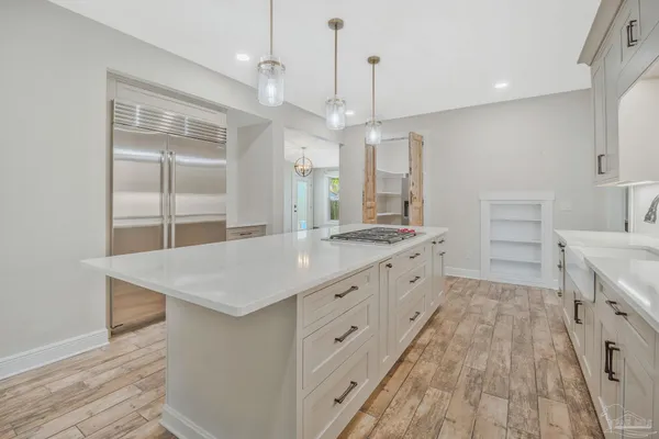 an empty room with wooden floor mirror and windows