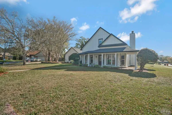 a front view of house with yard and trees in the background