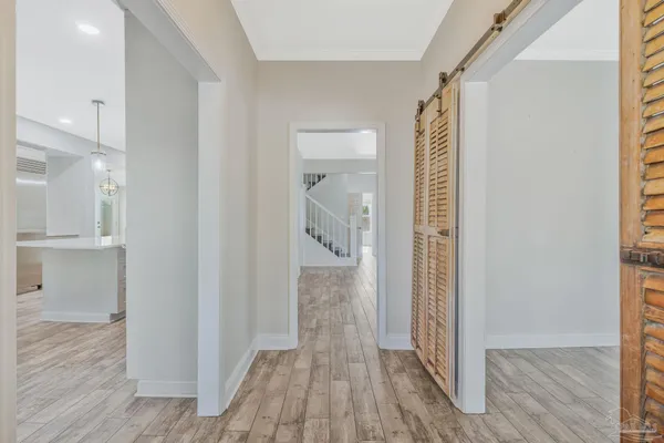 a view of an empty room with window and wooden floor