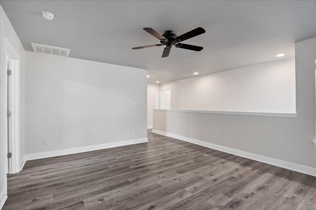 114 Aria Ridge, Unit 802 Lakeway, TX 78738 - Photo 17 of 30 a view of an empty room with wooden floor and a window