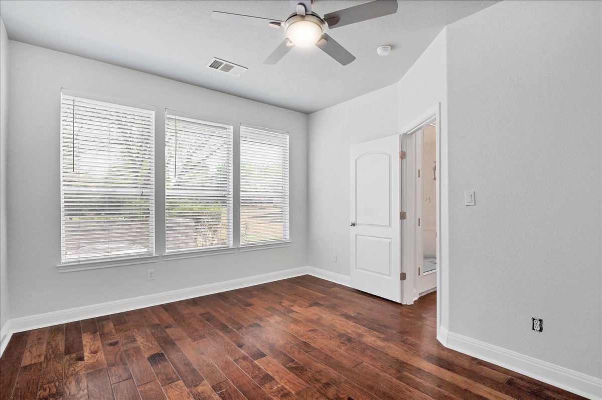 114 Aria Ridge, Unit 802 Lakeway, TX 78738 - Photo 23 of 30 a view of an empty room with wooden floor and a window
