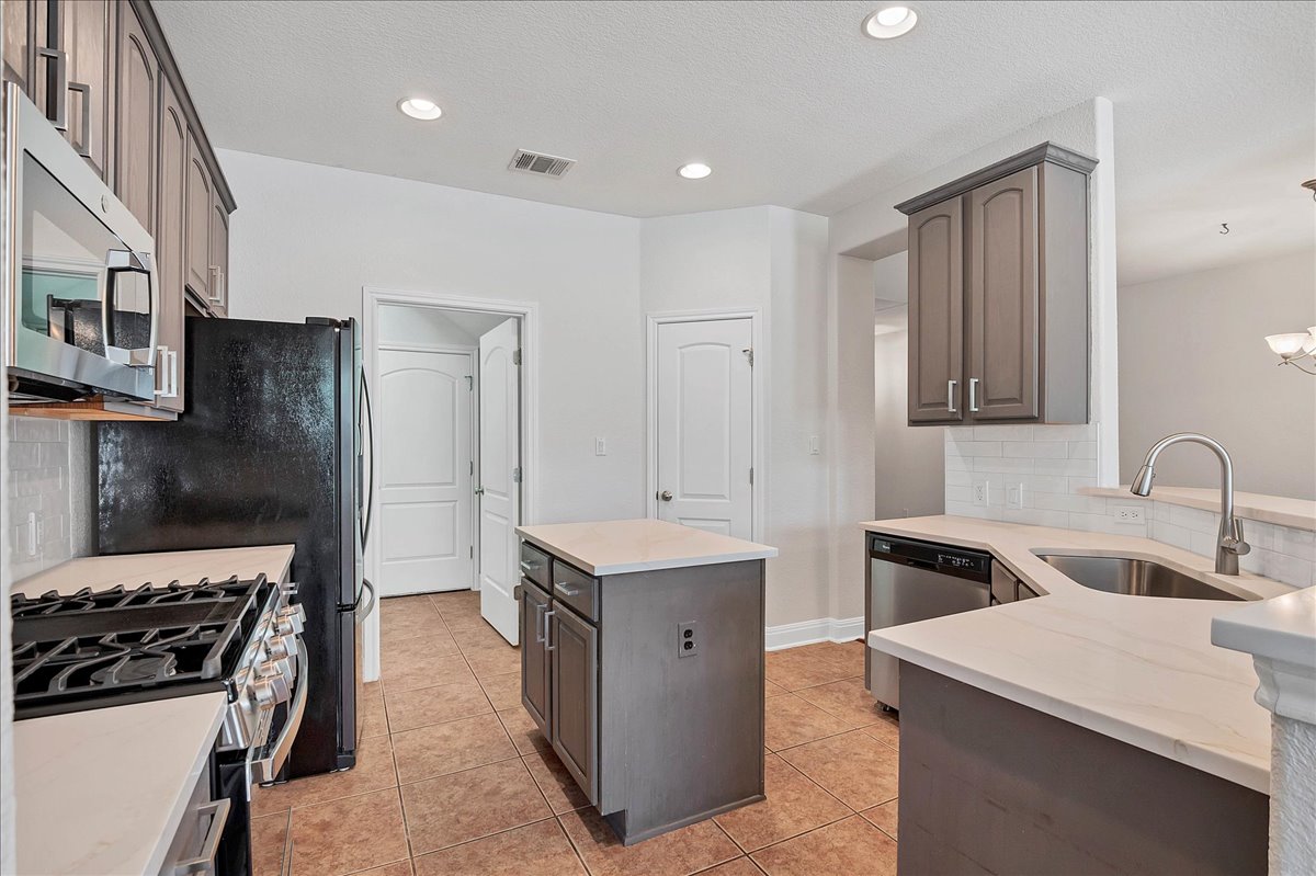 114 Aria Ridge, Unit 802 Lakeway, TX 78738 - Photo 8 of 30 a kitchen with a sink stove and refrigerator