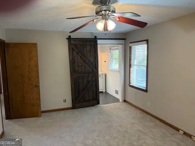 a view of empty room with window and chandelier fan