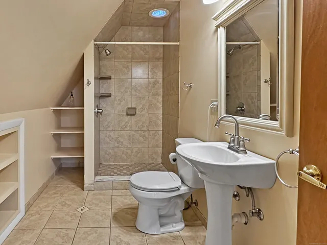 a picture of a bathroom with a white wall and a window