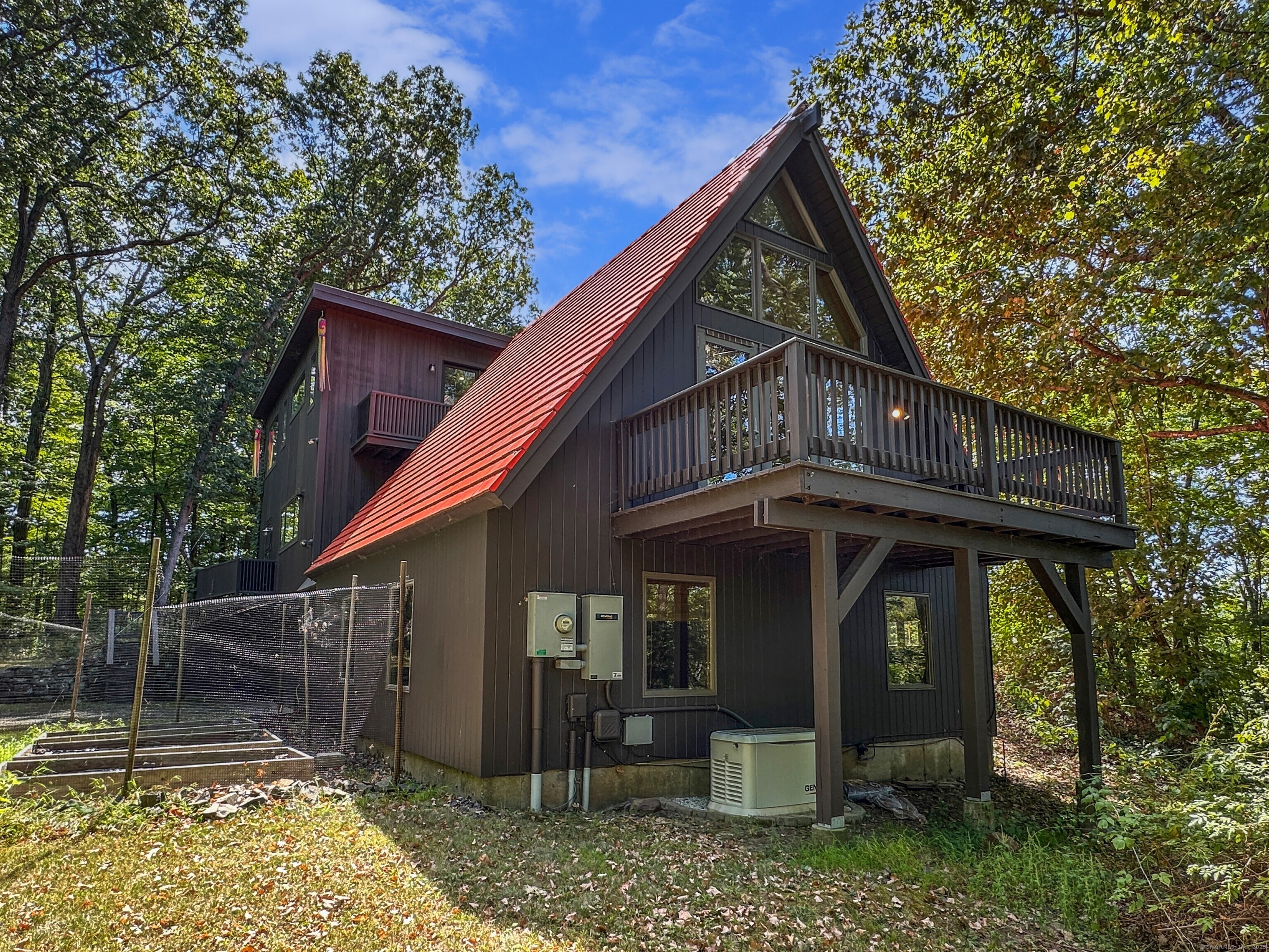 301 Bell Street Middletown, CT 06457 - Photo 7 of 40 a view of a wooden house with large windows and a small yard