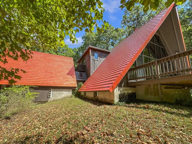 a backyard of a house with wooden deck and a garden
