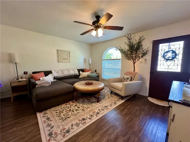 a living room with furniture a chandelier and a rug