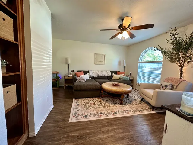 a living room with furniture a window and a ceiling fan