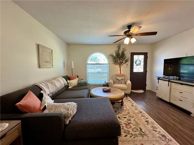 a living room with furniture a large window and a flat screen tv