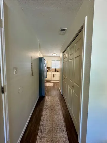 a view of a hallway with wooden floor