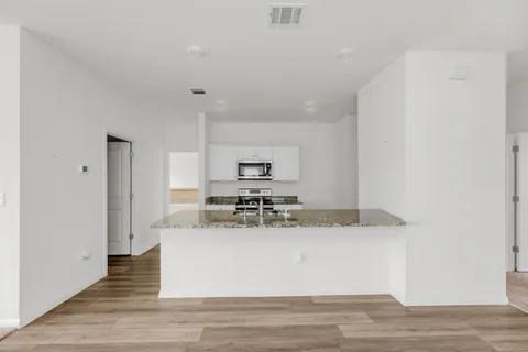 a view of kitchen with stainless steel appliances granite countertop refrigerator sink and stove