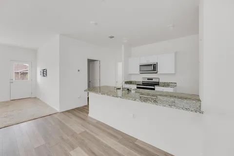 a kitchen with granite countertop a refrigerator and a stove