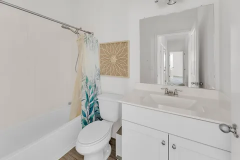 a bathroom with a sink a toilet a mirror and shower