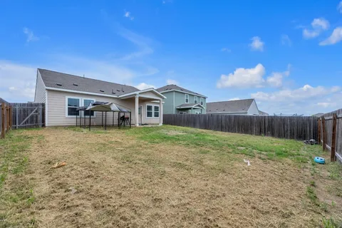 a view of a house with backyard and sitting area