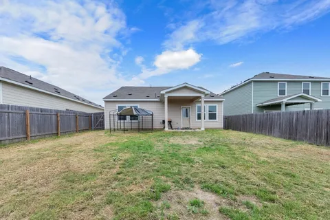 a backyard of a house with table and chairs
