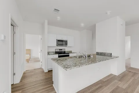 a kitchen with stainless steel appliances granite countertop a sink stove and refrigerator