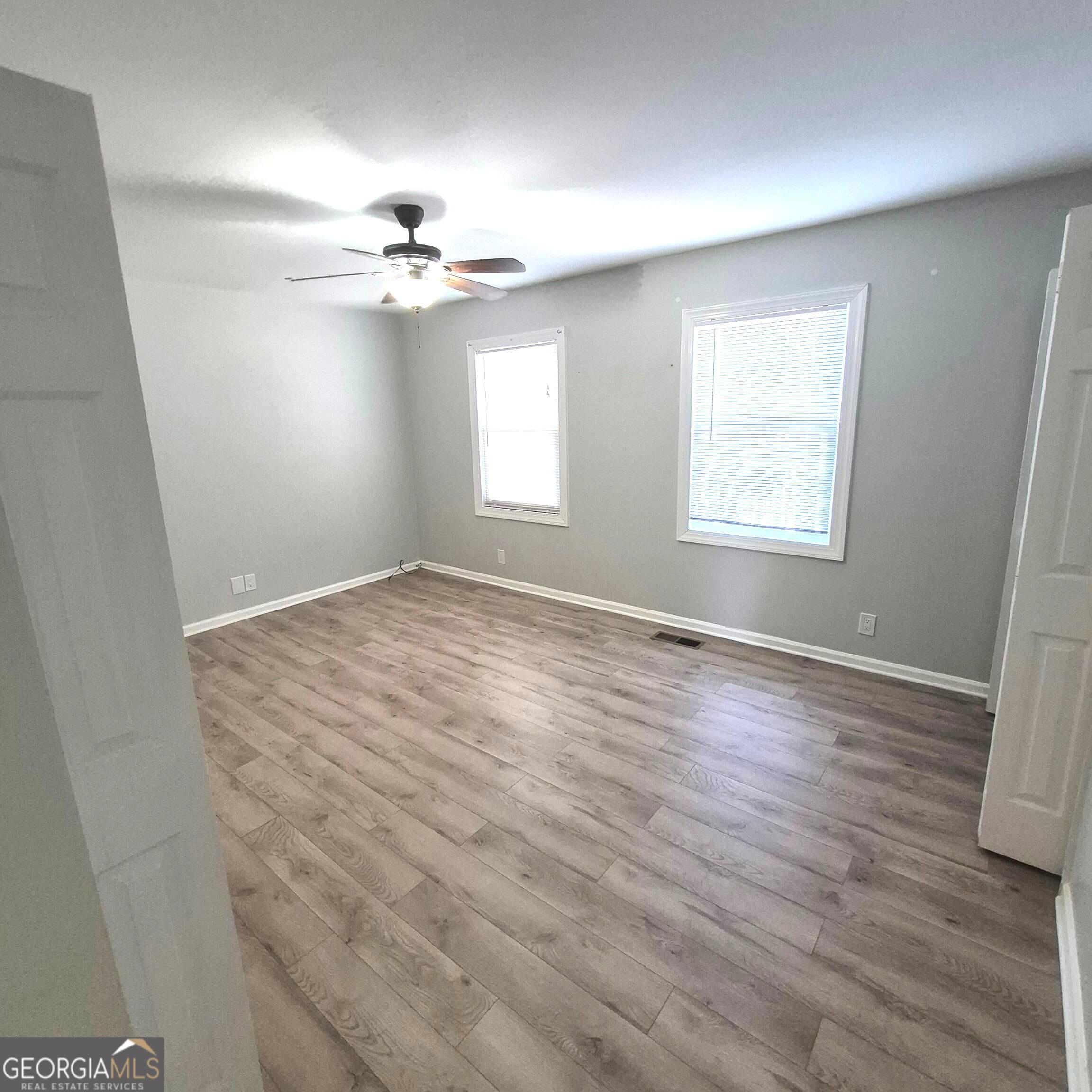 195 Springdale Court Macon, GA 31210 - Photo 13 of 14 an empty room with wooden floor ceiling fan and windows
