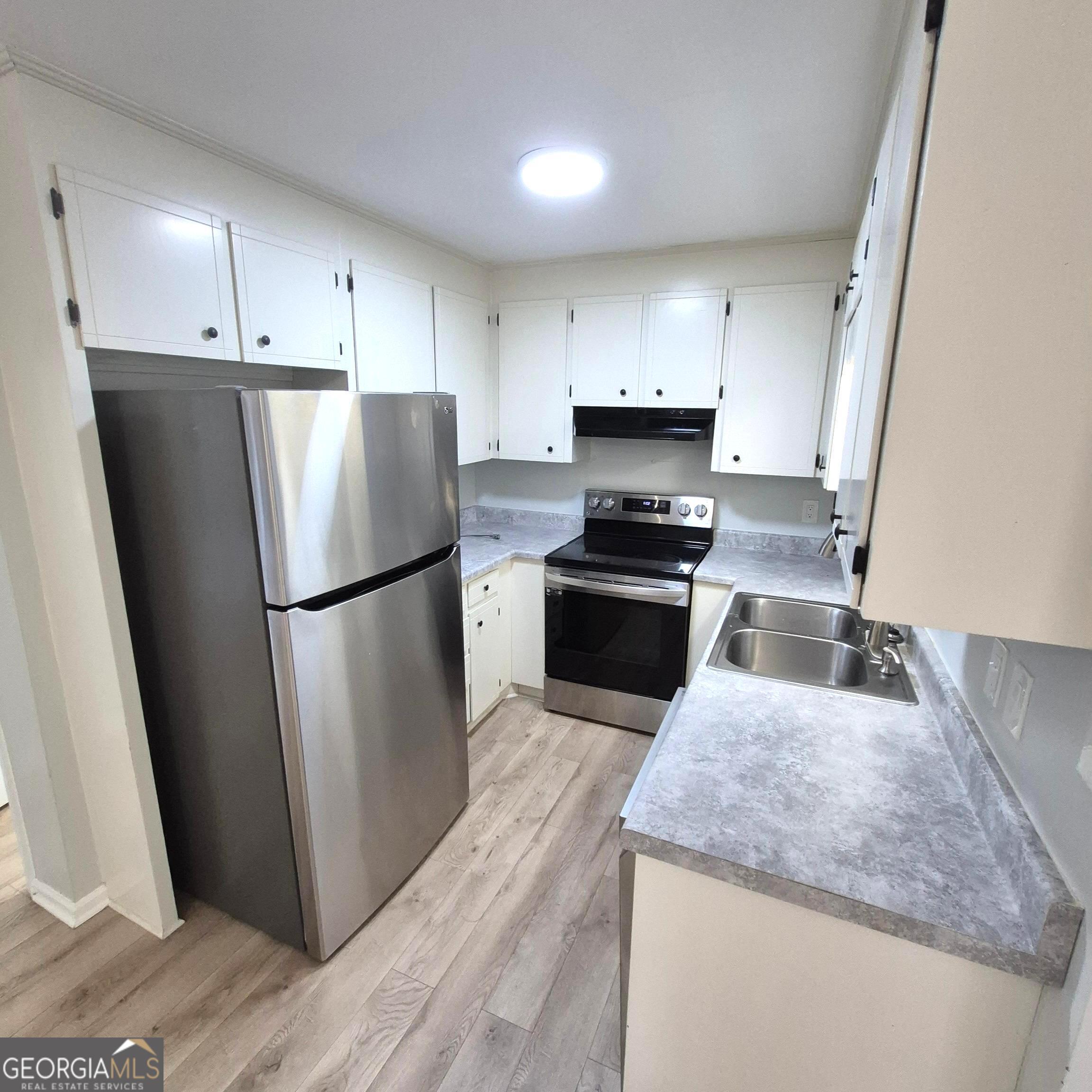 195 Springdale Court Macon, GA 31210 - Photo 7 of 14 a kitchen with wooden cabinets and stainless steel appliances