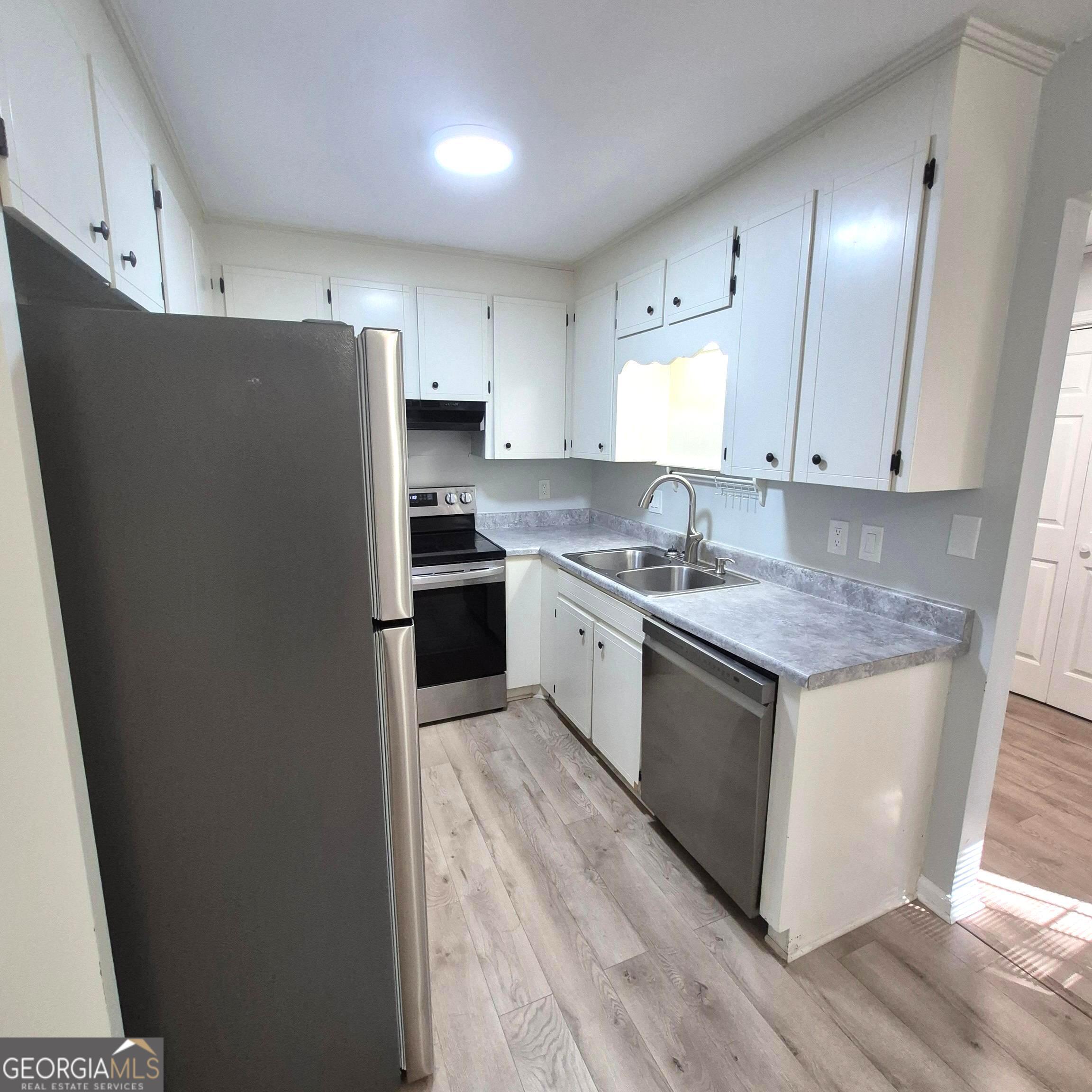195 Springdale Court Macon, GA 31210 - Photo 8 of 14 a kitchen with stainless steel appliances granite countertop a stove a refrigerator a sink a refrigerator and white cabinets