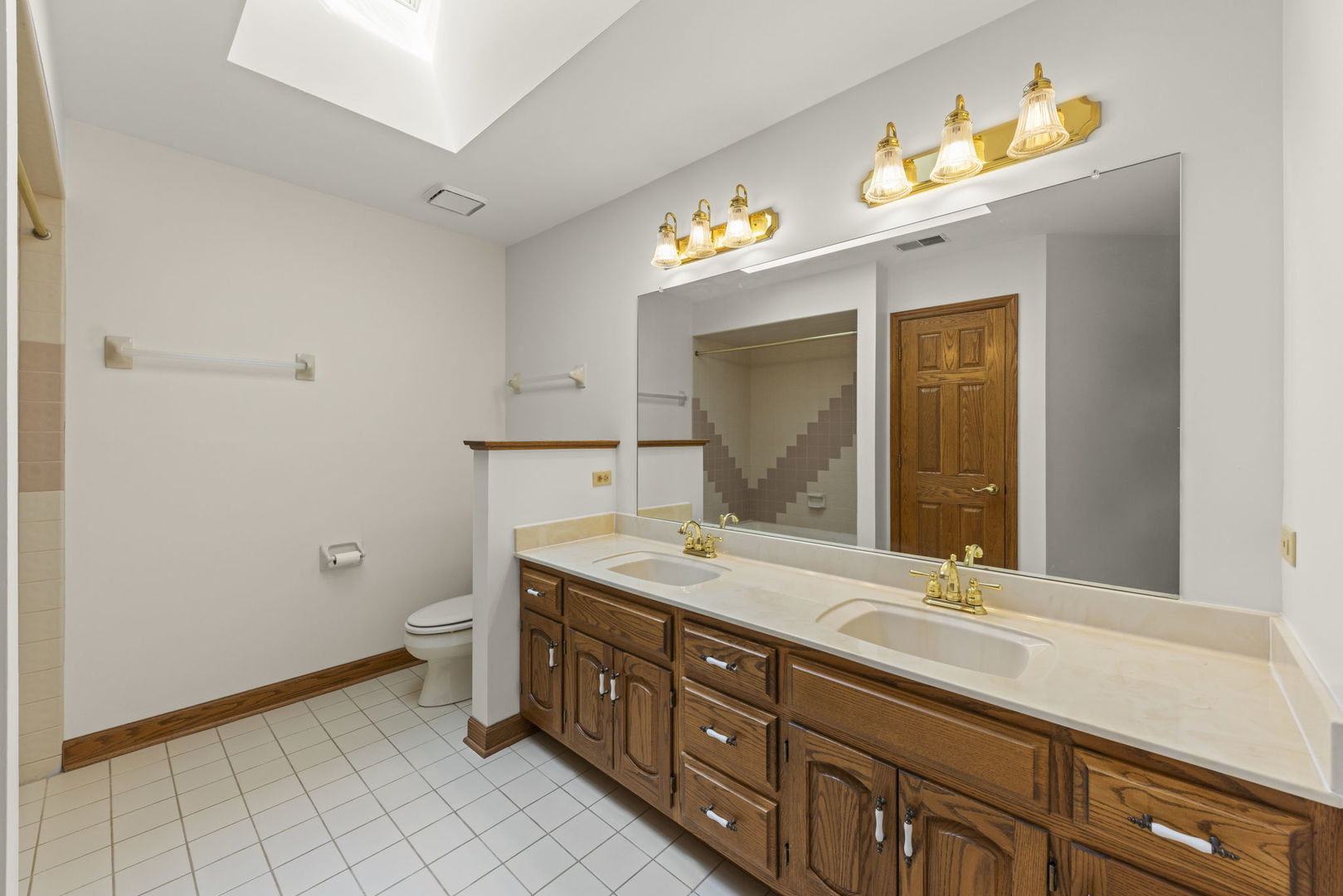 18040 Perth Avenue Homewood, IL 60430 - Photo 31 of 44 a spacious bathroom with a granite countertop sink a toilet and mirror