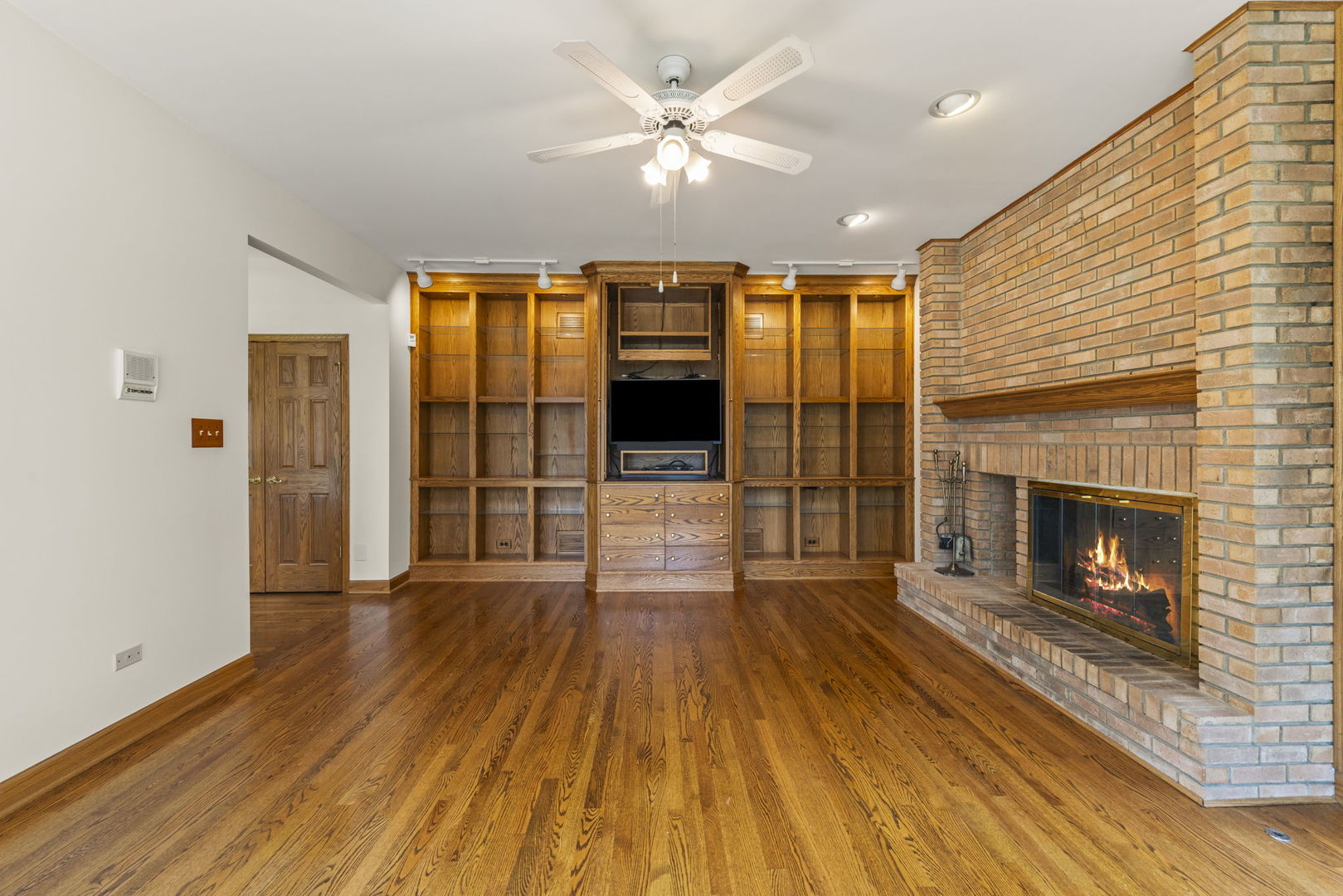 18040 Perth Avenue Homewood, IL 60430 - Photo 6 of 44 a view of a livingroom with wooden floor a fireplace window and a ceiling fan
