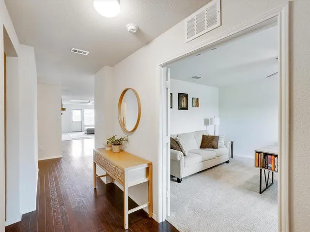 a living room with furniture a table and wooden floor