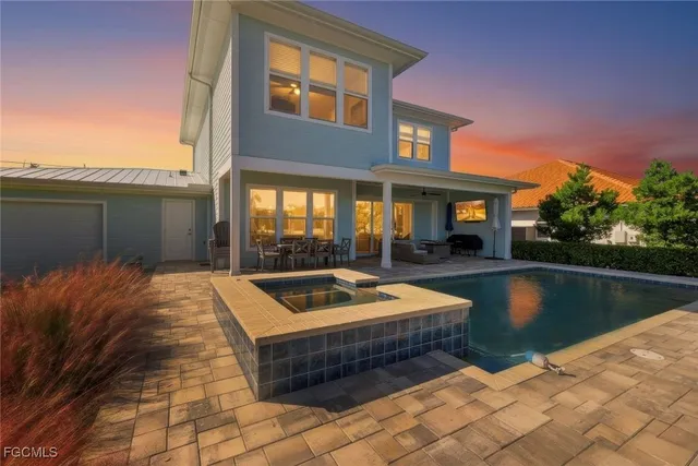 a view of swimming pool with outdoor seating and house in the background