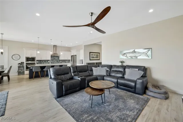 a kitchen with stainless steel appliances kitchen island granite countertop a table chairs sink and cabinets