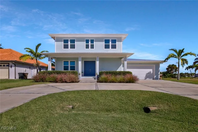 a front view of a house with a yard and potted plants