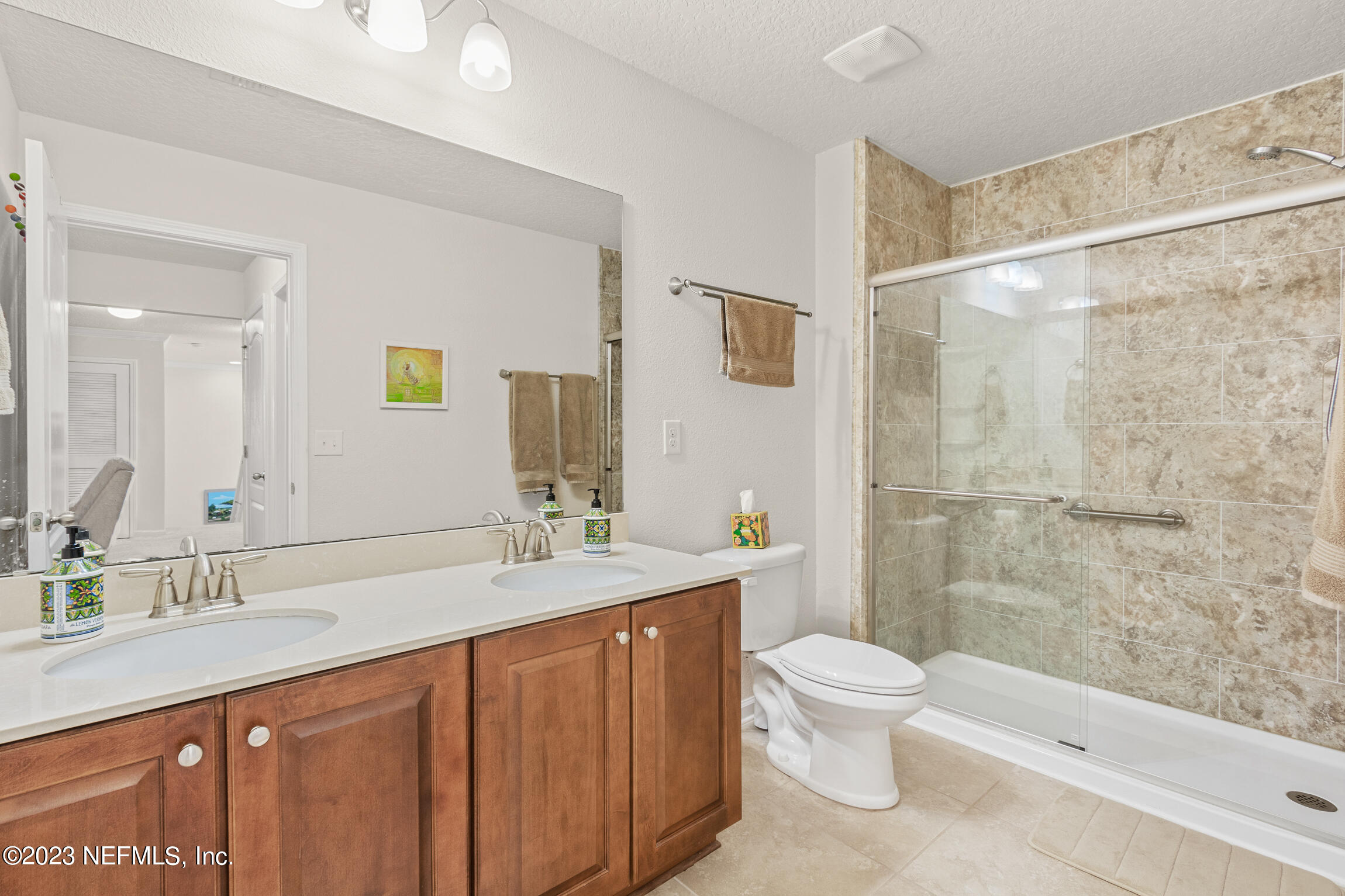 57 Deer Crossing Road St. Augustine, FL 32086 - Photo 30 of 48 a bathroom with a granite countertop sink a toilet a mirror and shower