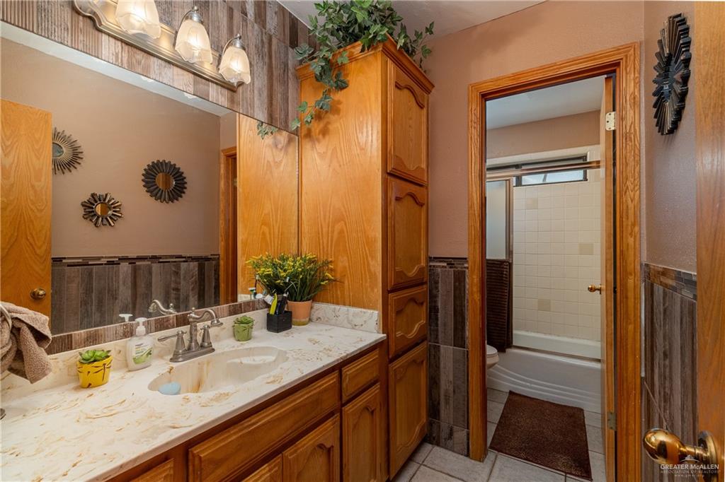 4112 Fm 493 Road Donna, TX 78537 - Photo 13 of 18 a bathroom with a granite countertop sink and a mirror