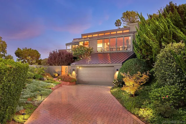 a front view of a house with a yard and fountain in middle