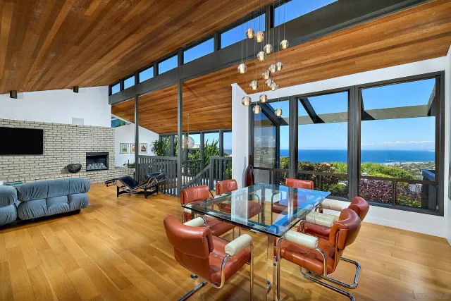 a view of a dining room with furniture large windows and wooden floor