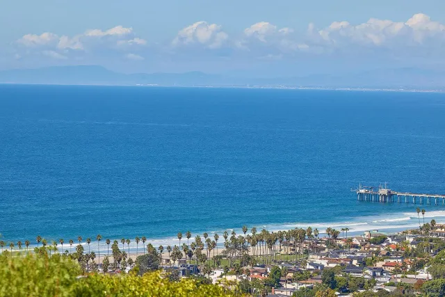 a view of a roof deck with couches and wooden floor