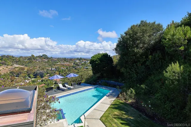 a view of a house with pool and a yard