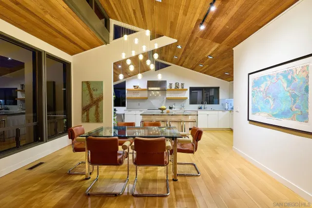 a dining hall with stainless steel appliances kitchen island granite countertop a dining table and chairs