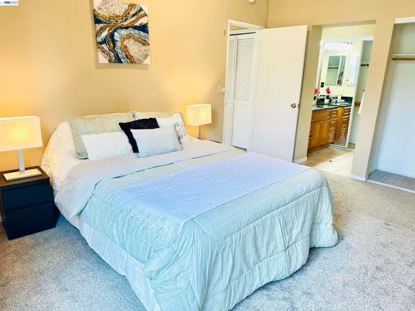 a bedroom with a bed and painting on the wall