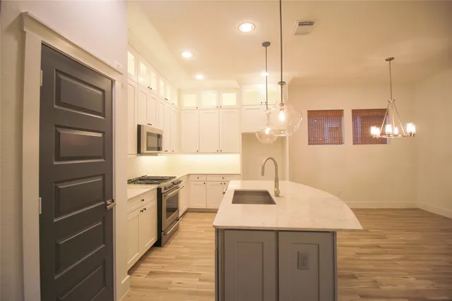 a kitchen with kitchen island a sink stainless steel appliances and cabinets