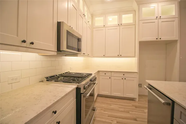 a kitchen with granite countertop cabinets stainless steel appliances and sink