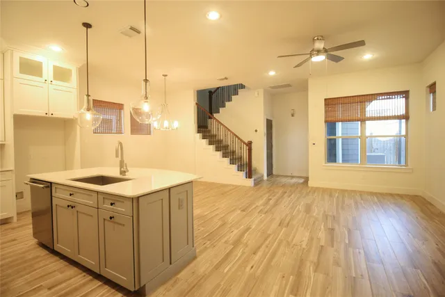a kitchen with a sink window and a wooden floor