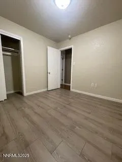 an empty room with wooden floor and closet