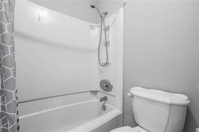 a bathroom with a toilet and a bath tub