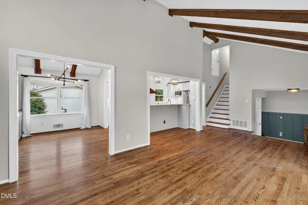 a view of a hallway with wooden floor and stairs