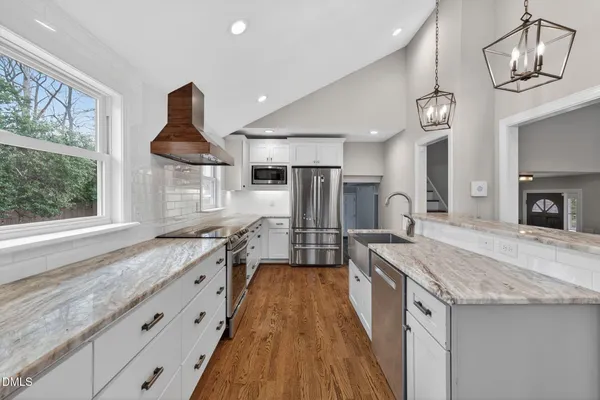 a large kitchen with granite countertop a sink and a stove