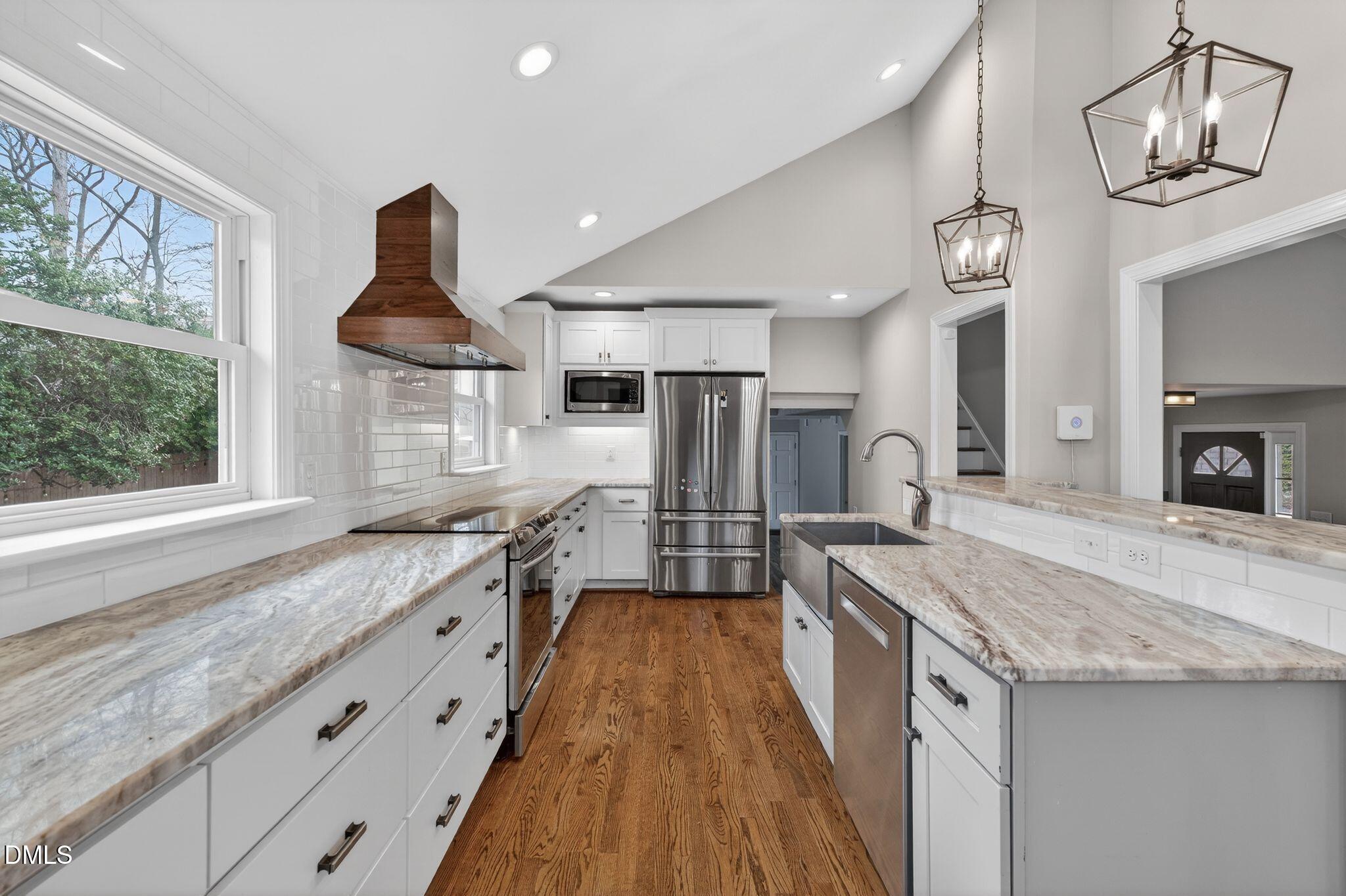 1201 Chardon Court Raleigh, NC 27609 - Photo 7 of 47 a large kitchen with granite countertop a sink and a stove