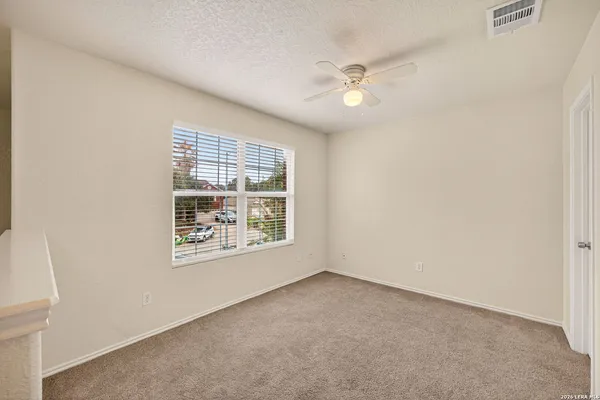 an empty room with windows and fan