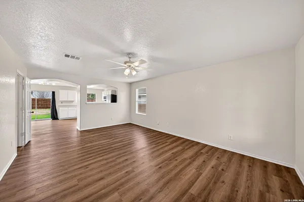 a view of an empty room with wooden floor