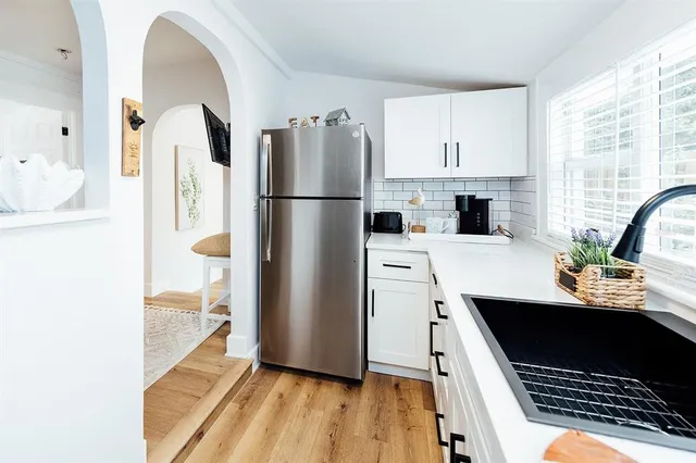 a kitchen with appliances a sink a stove and a window